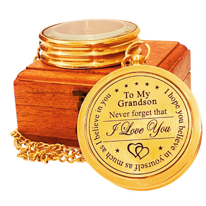 Gold compass with engraved message in a wooden box.